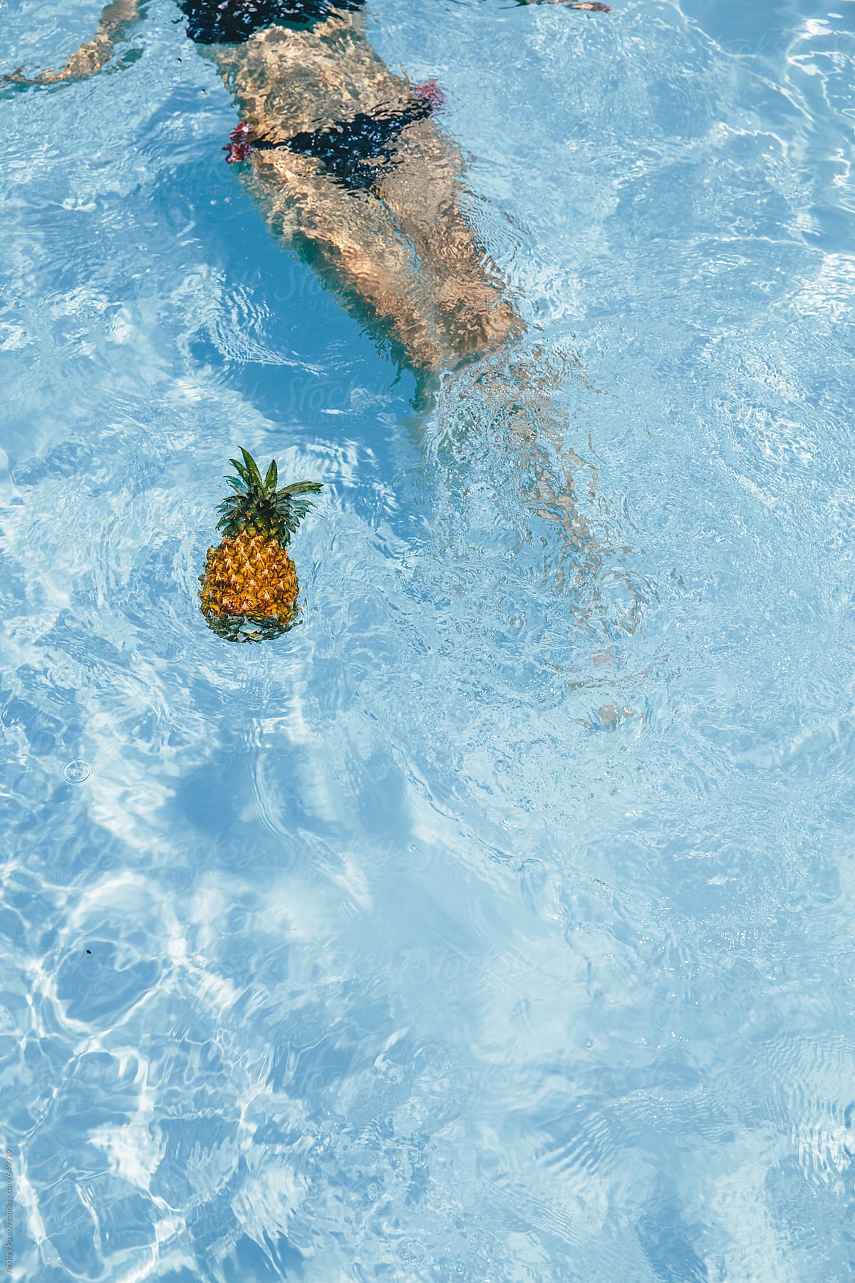 Woman and pineapple in a pool