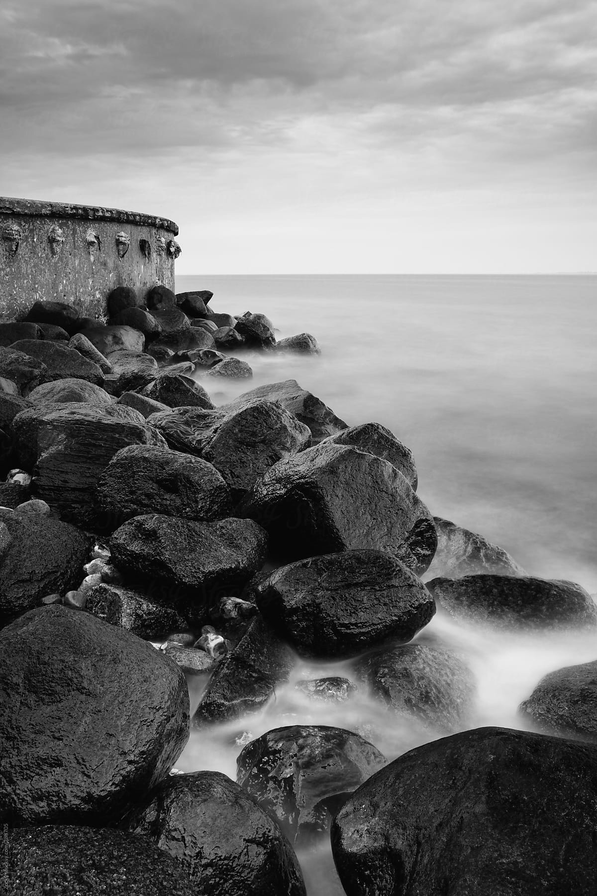 Beautiful black and white landscape of rocky shore at sunset