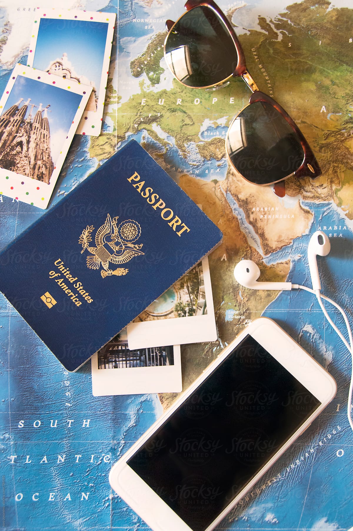 Passport, sunglasses, travel playlist and Polaroids