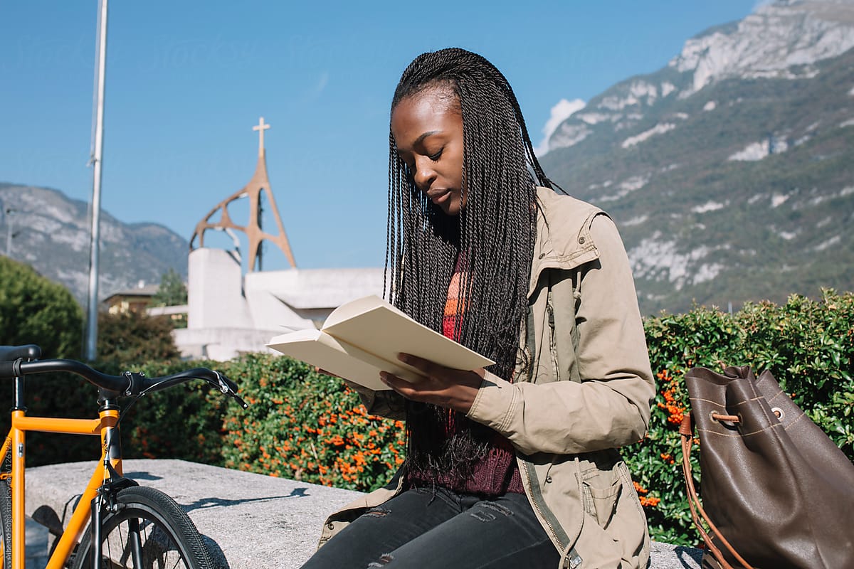 Female reading book on mountain background