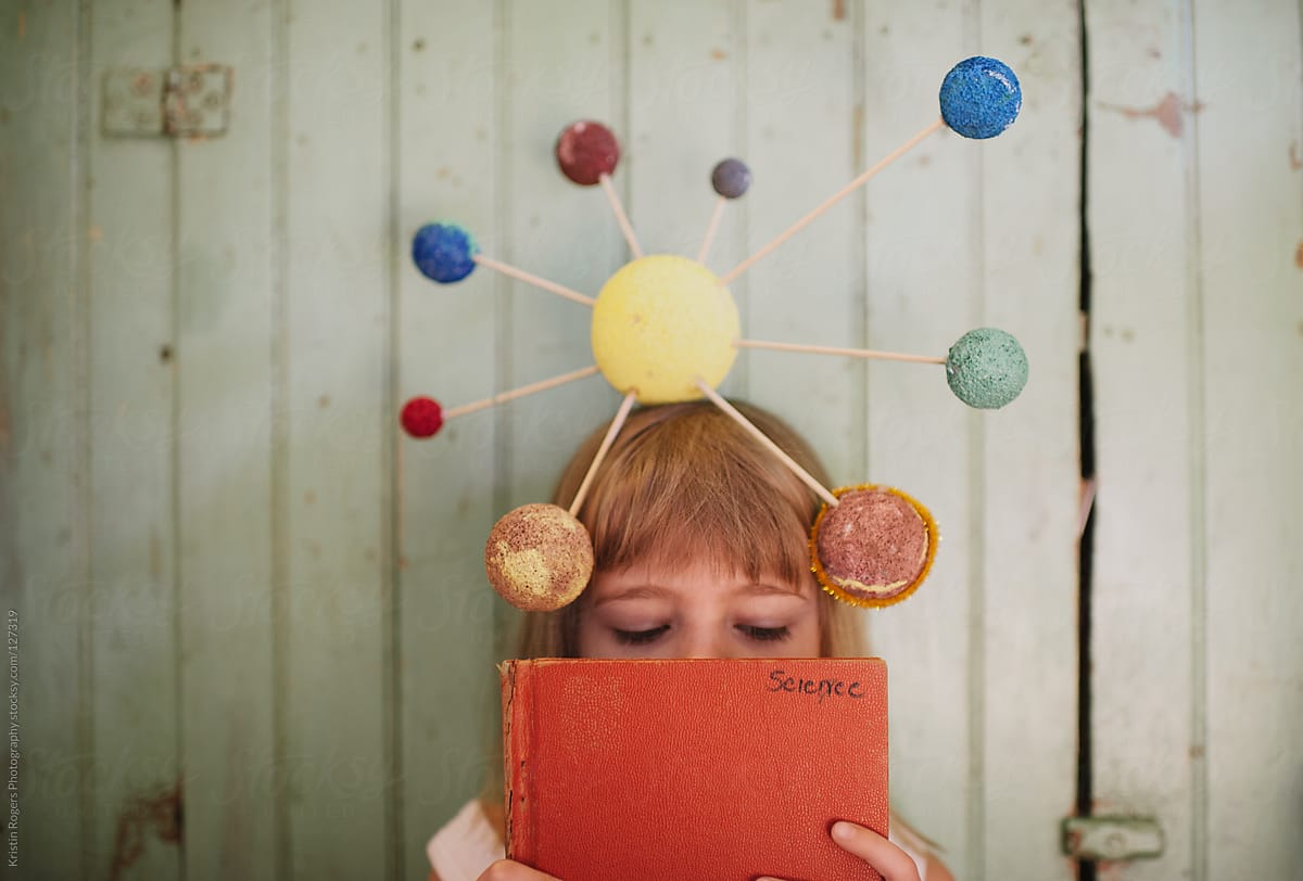 Young girl with playing with her homemade solar system craft