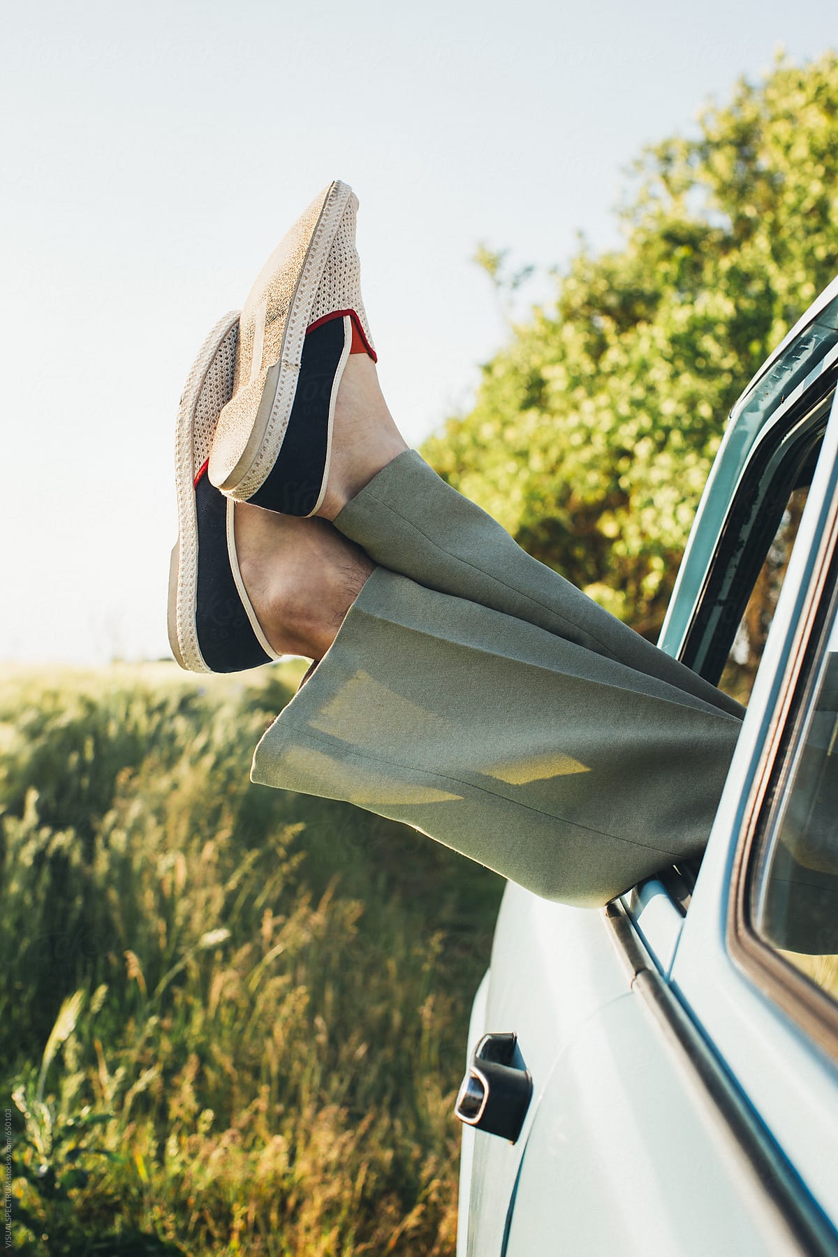 Feet of Retro-Styled Young Guy Sticking Out Car Window