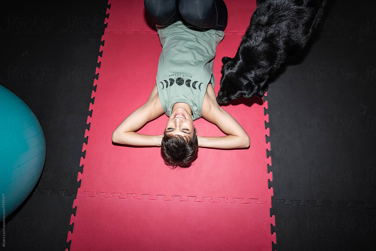 Woman Petting Dog During Home Gym Workout