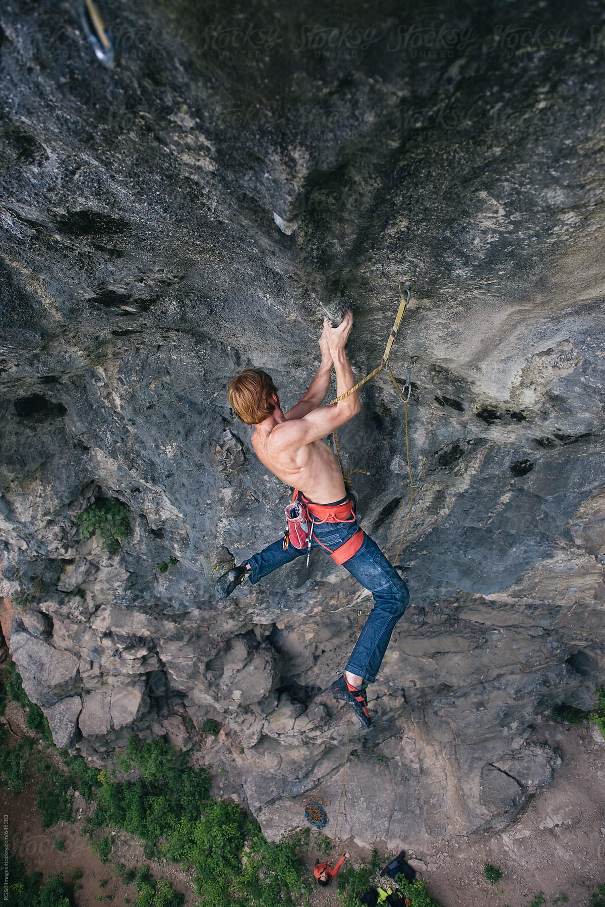 Powerful rock climber hanging from his hands