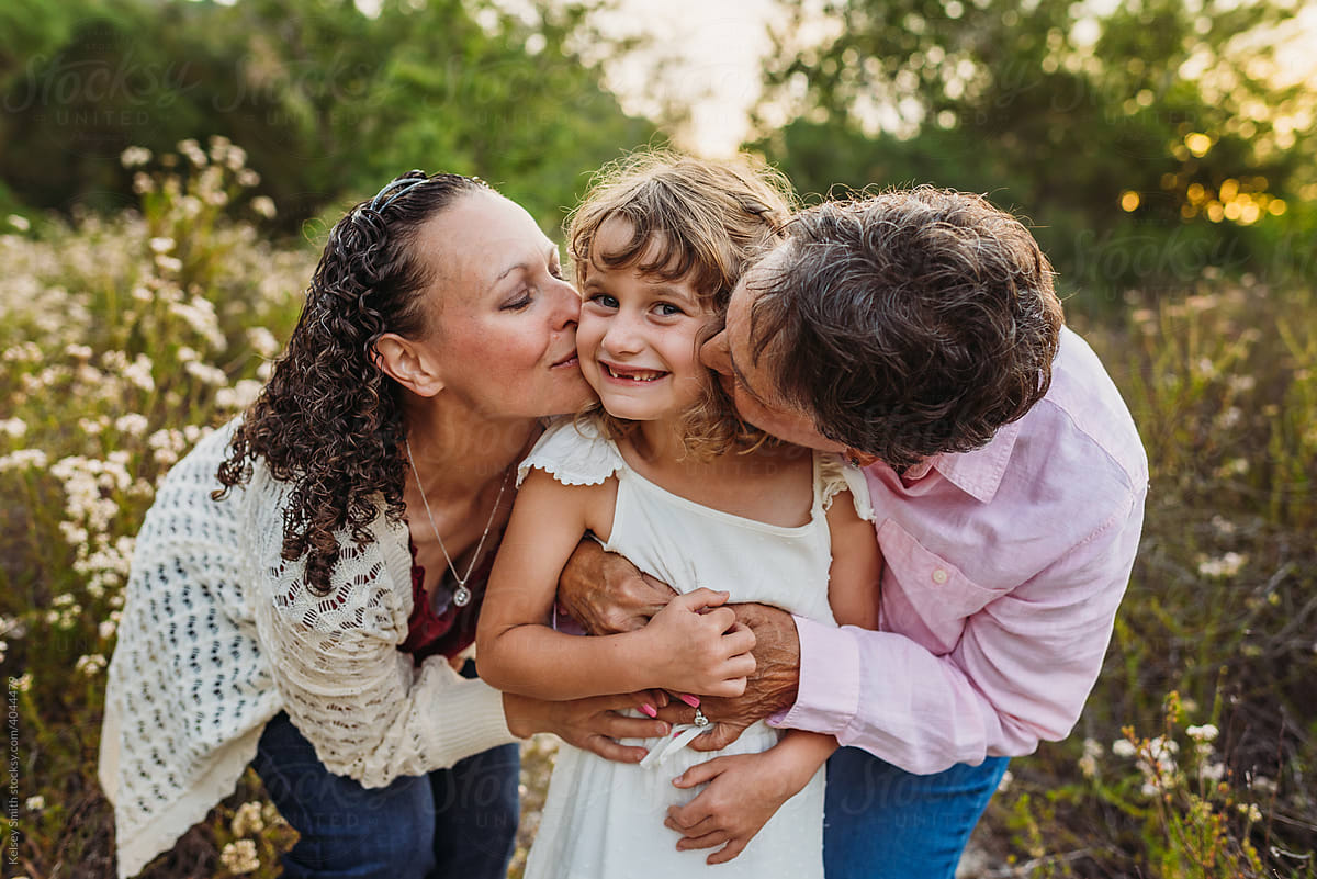 Grandparent and Mother Kissing Girl