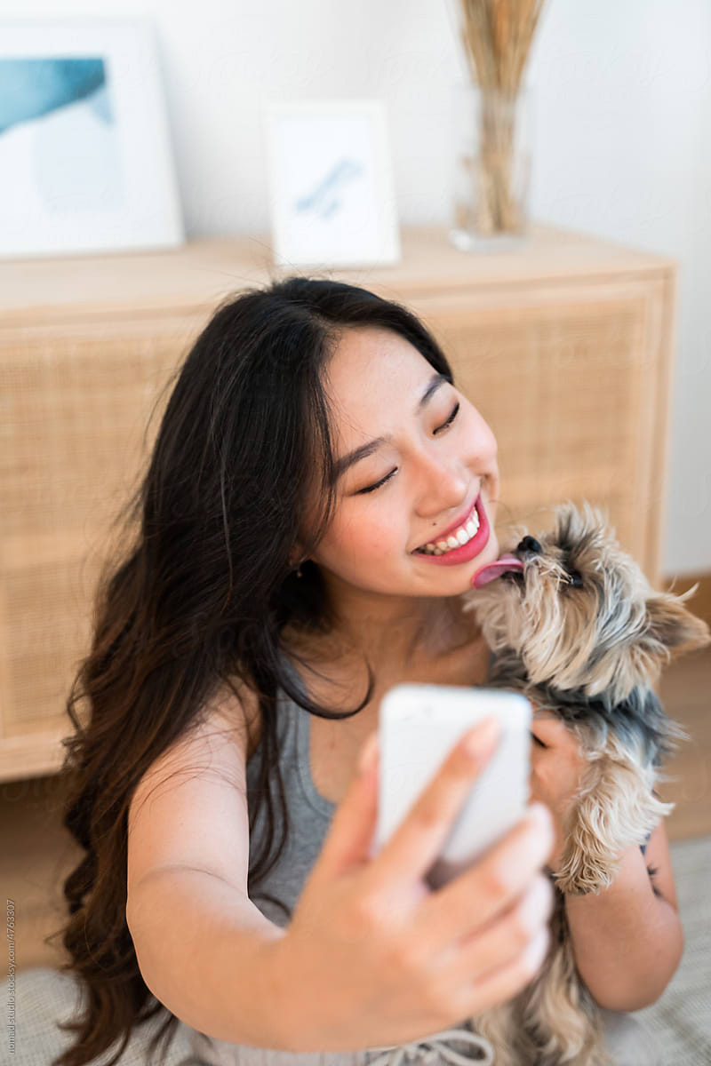 Smiling woman taking selfies with her dog.