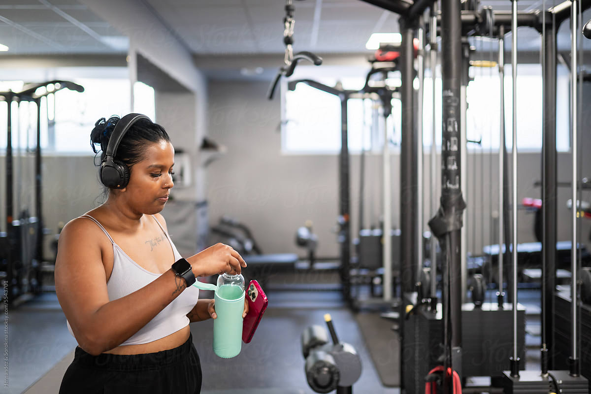 Curvy Woman Drinking Water In The Gym