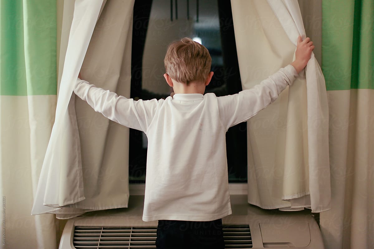 boy looking out of a hotel window