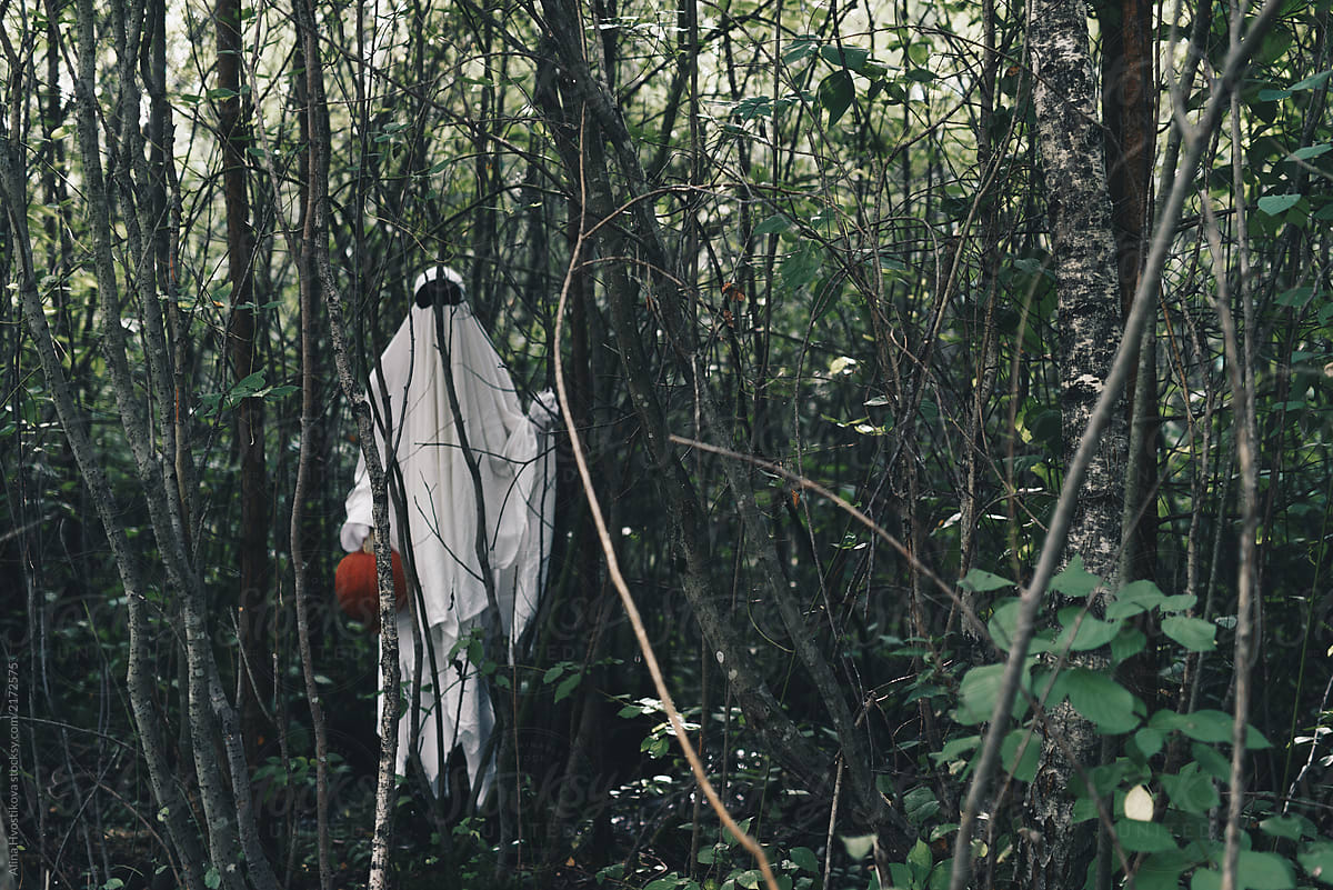 Ghost with pumpkin in forest
