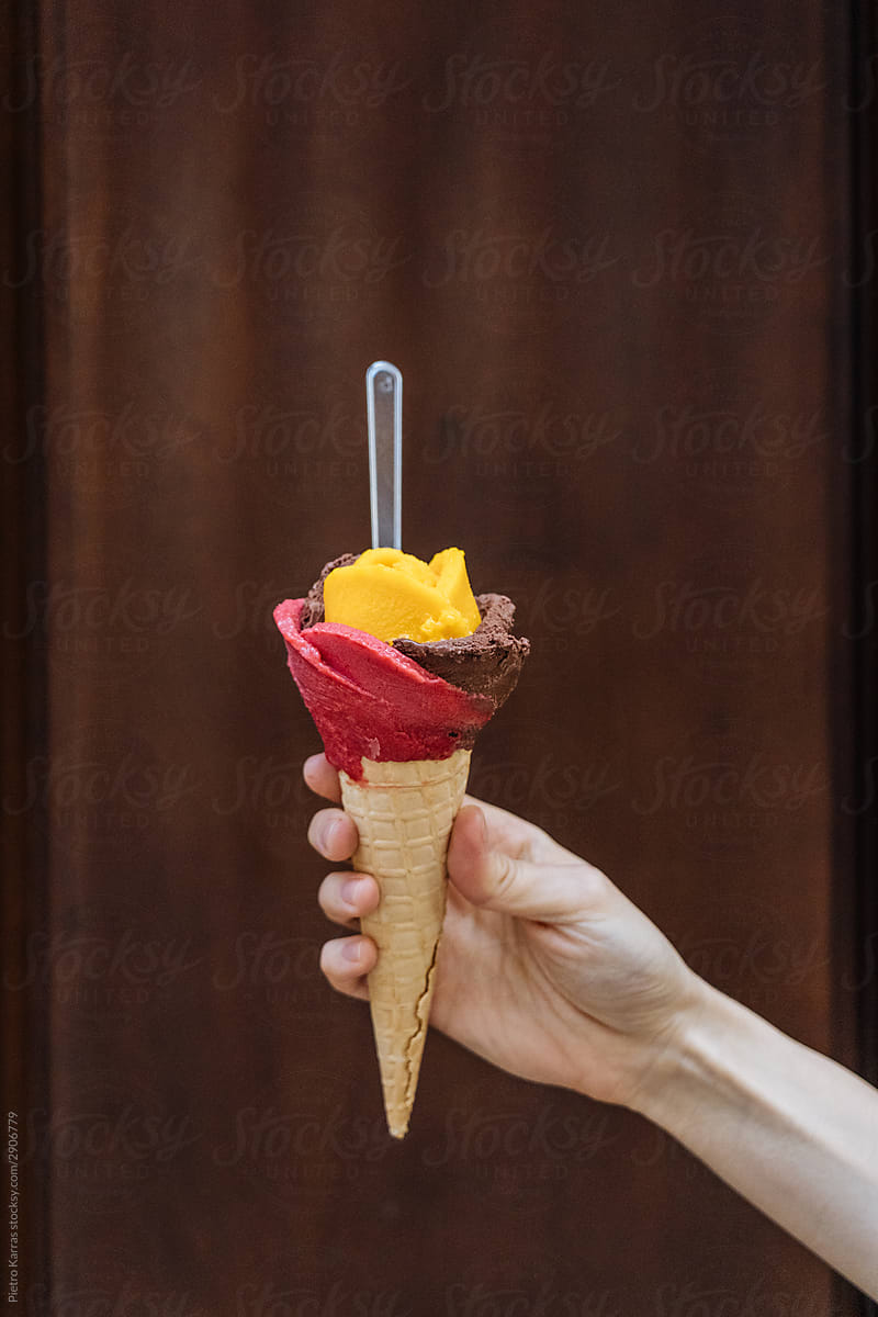 Woman holding exotic ice-cream cone with spoon