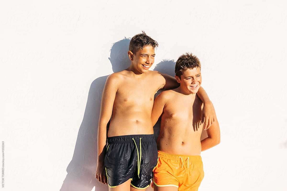 Brothers posing over white wall in summer day