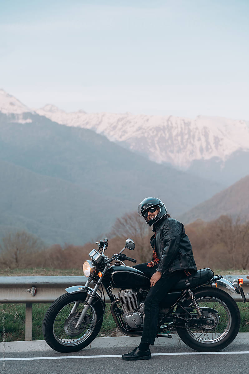 Male biker admiring mountains from road