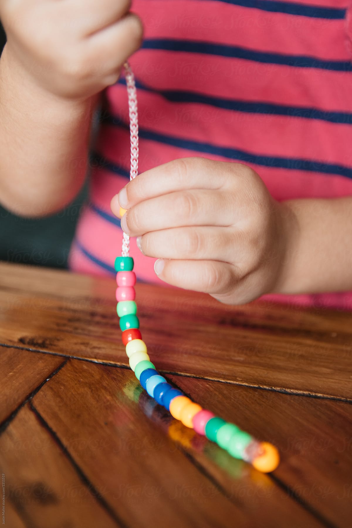 Preschool girl playing with beads.