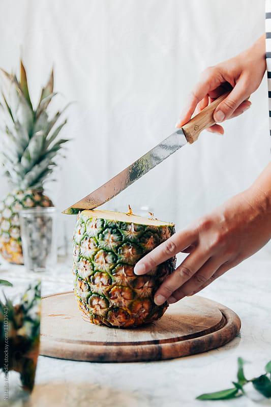 Woman cutting a pineapple