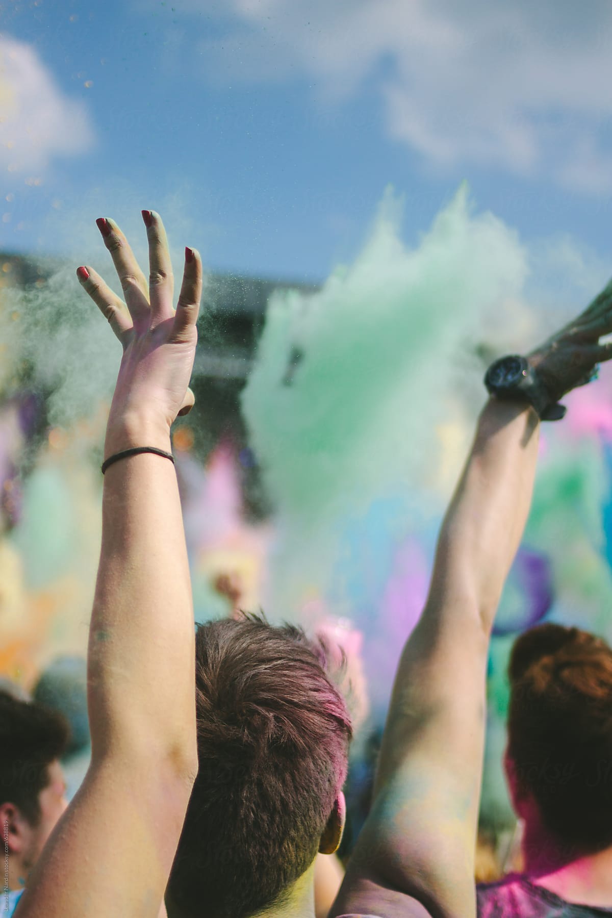 crowd throwing colorful powder in the air at a holi festival