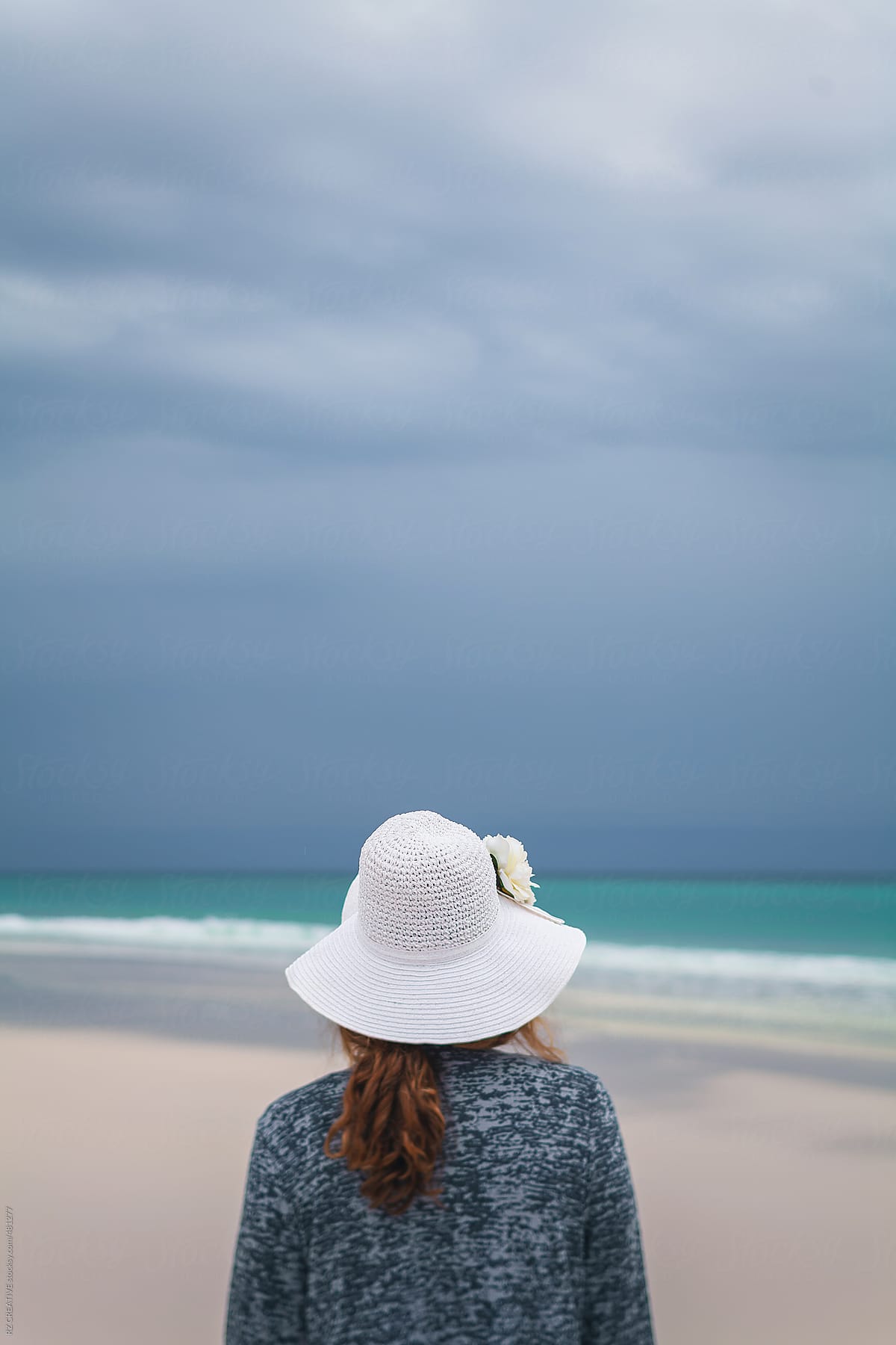 Woman with white sunhat at beach.