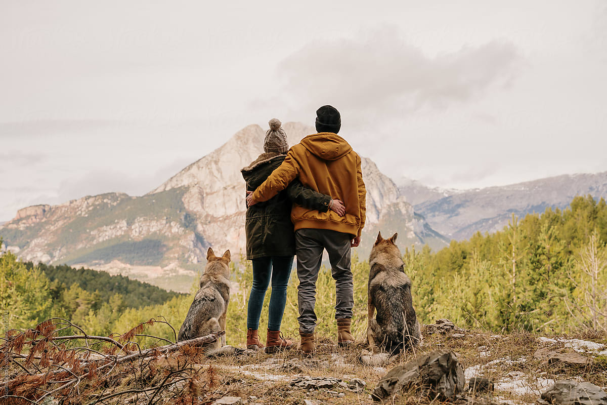Couple with wolf dogs hiking in the mountain