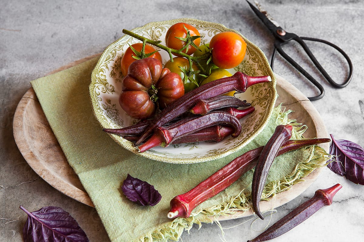 Bowl of red burgundy okra and heirloom tomatoes