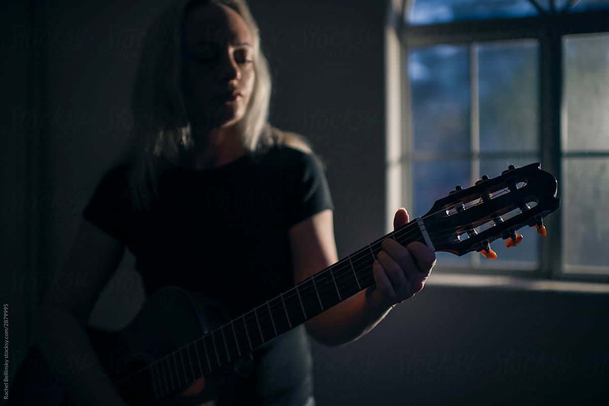A beautiful woman plays the guitar