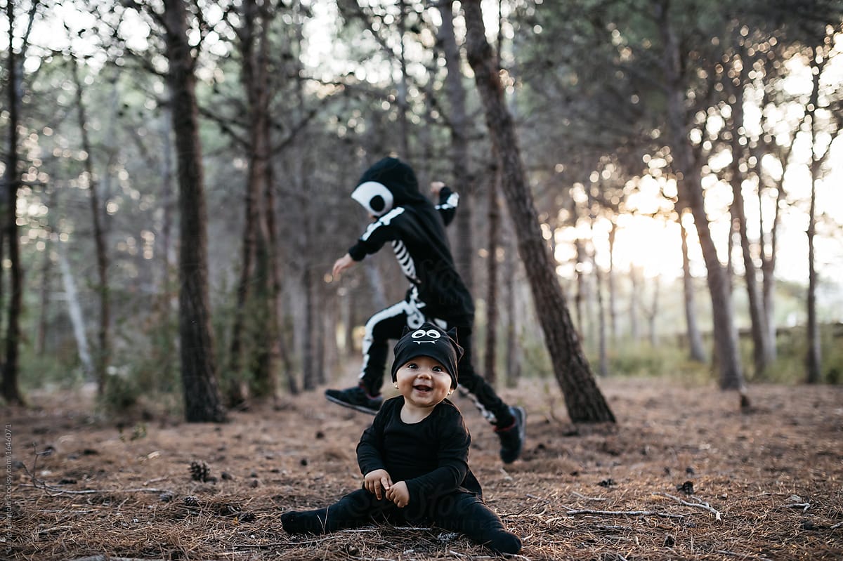 baby in black bat costume and running skeleton kid