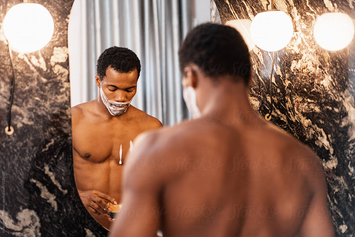 Shirtless Black Man Applying A Shaving Foam On His Face