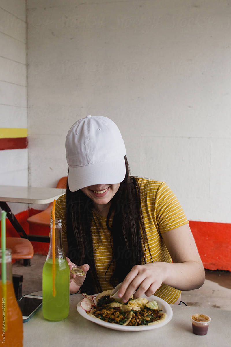 teenage girl eating taco in outdoor table