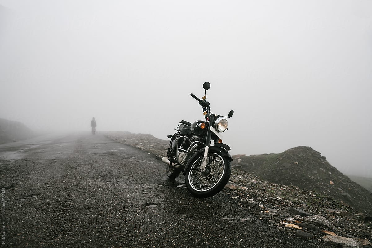 Black motorcycle parked on the foggy road