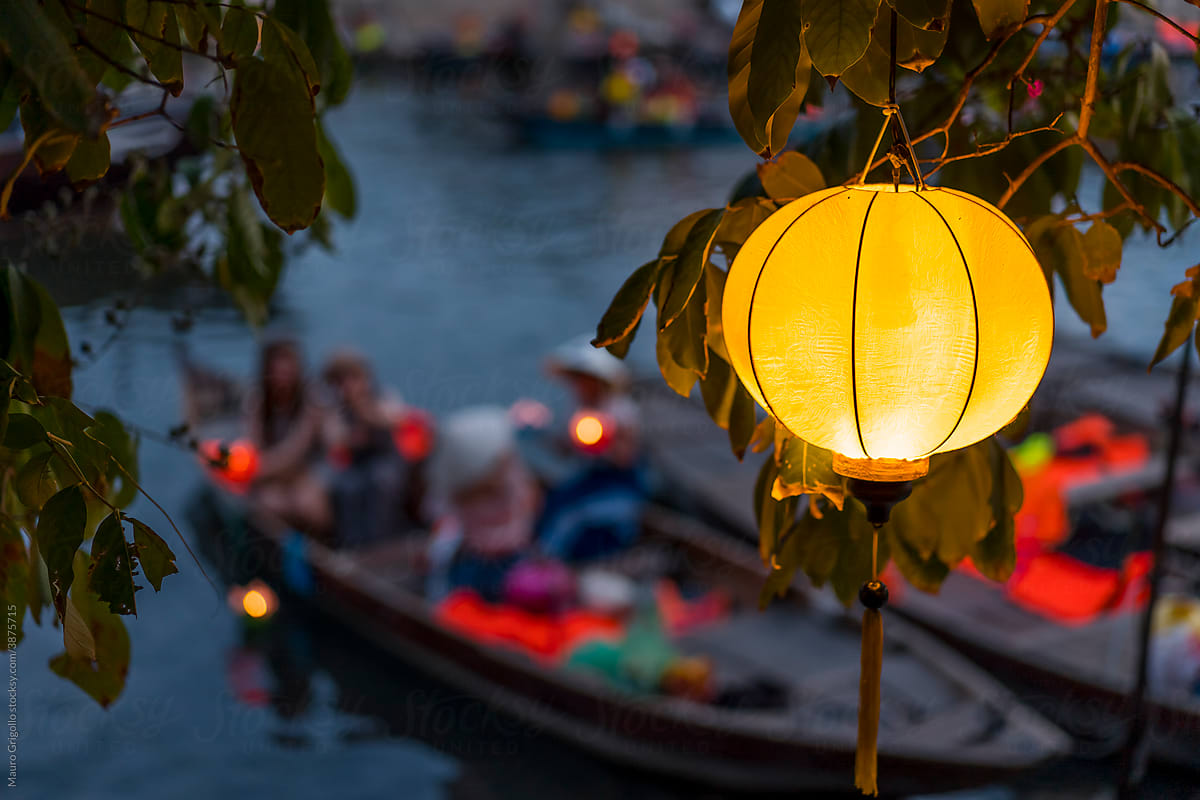A yellow Lantern on a tree along the river