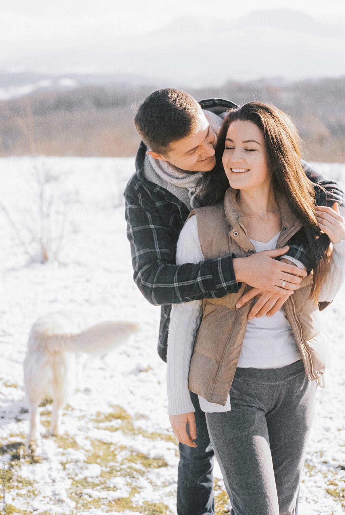 Embracing laughing couple in snowy hills