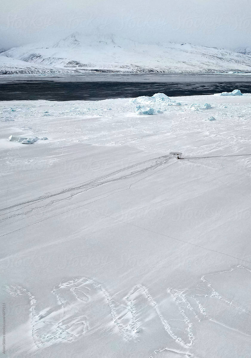 Greenlandic Inuit Eskimo indigenous hunter at Arctic sea ice hole