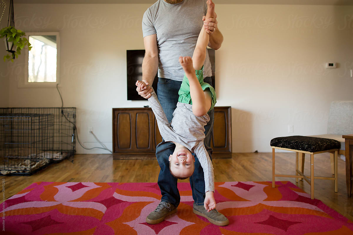 Father holds son upside down