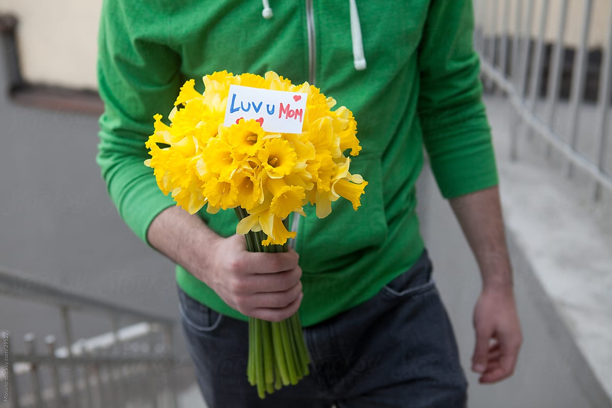 Man holding bouquet of narcissus.