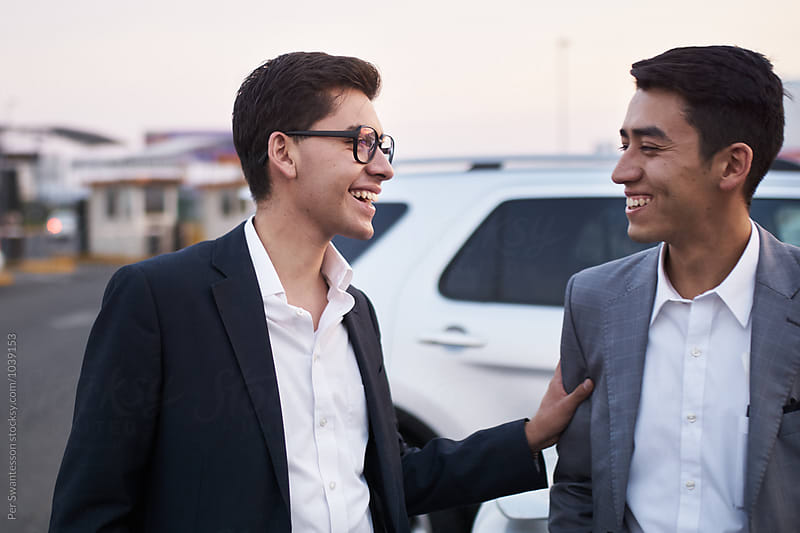 Young startup partners laughing together at parking garage