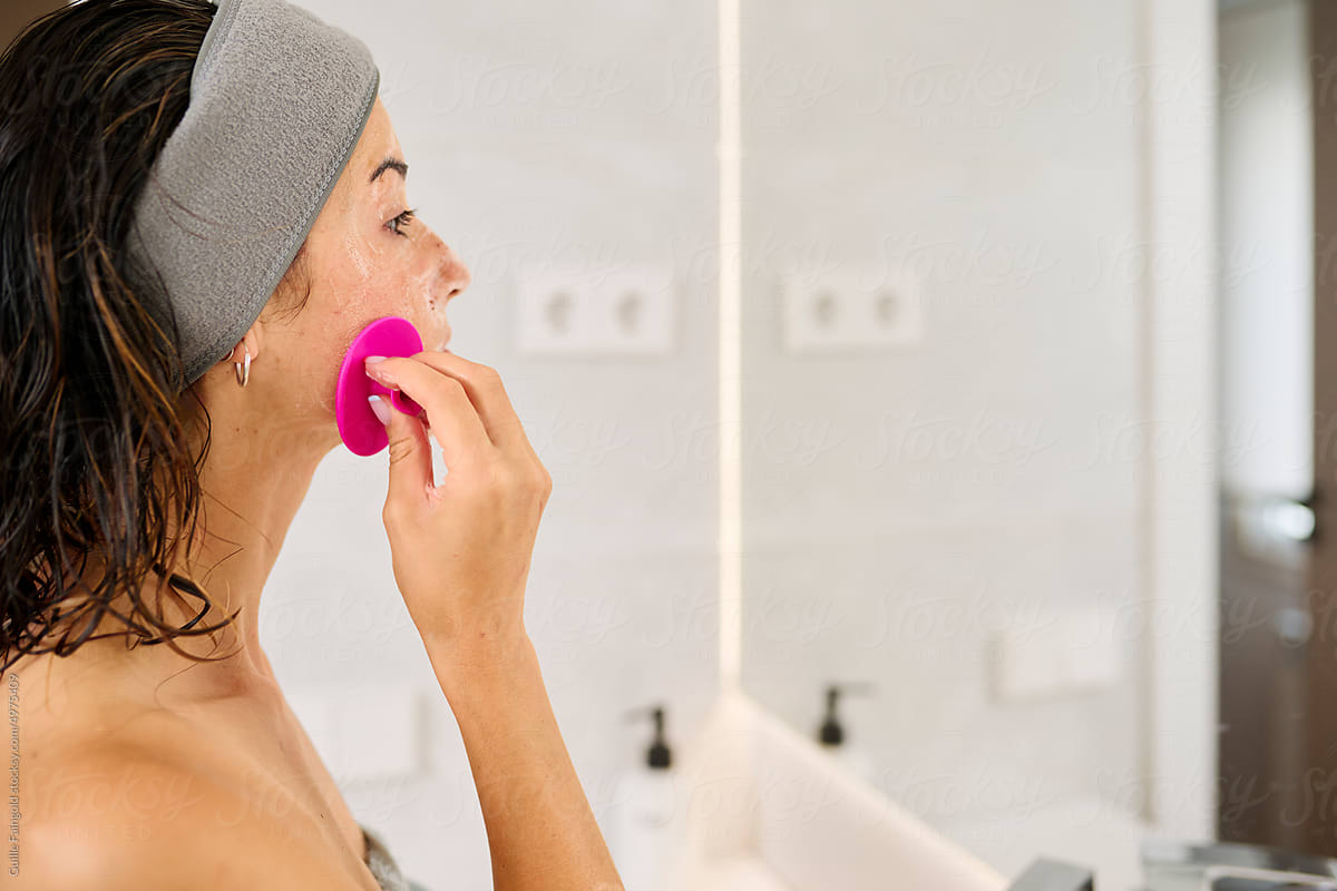 Woman washing face silicone cleanser.