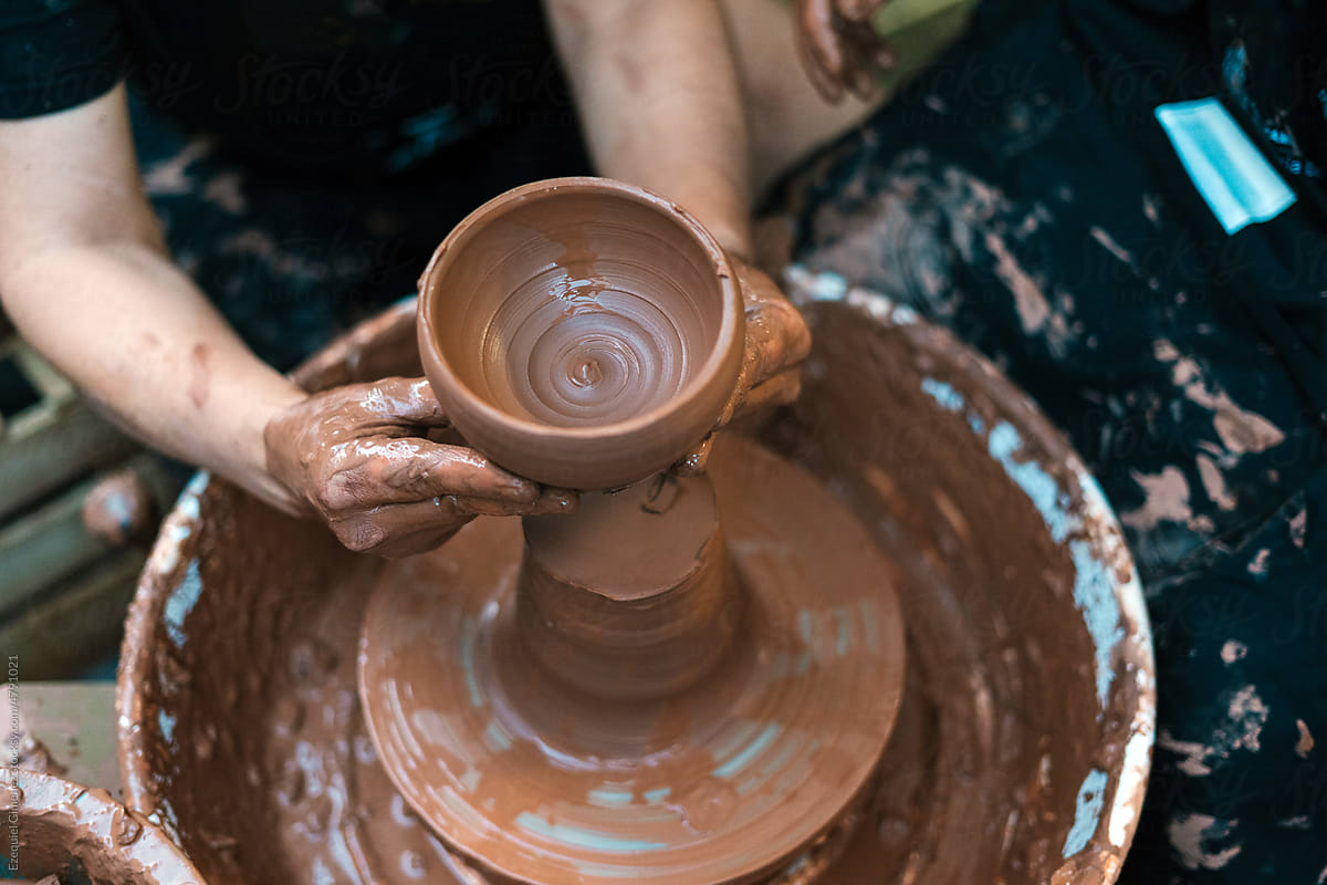 Faceless potter creating clay vase in workshop