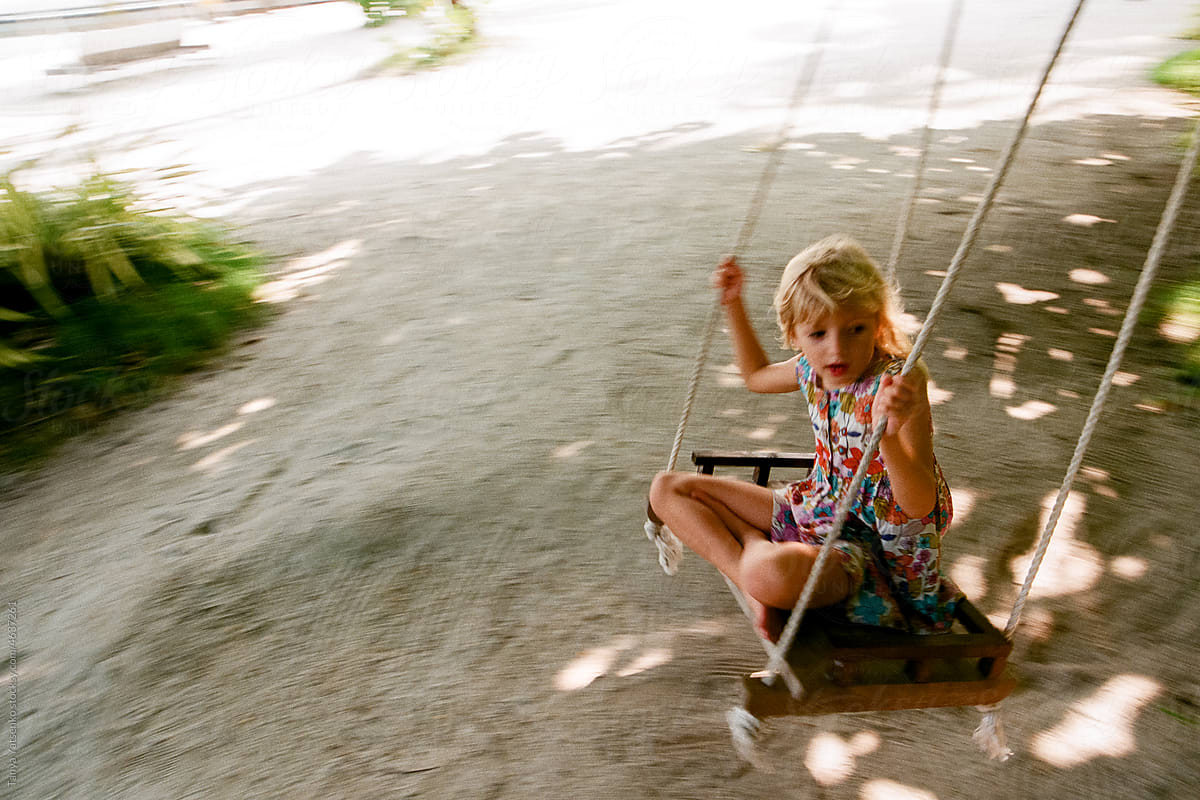 A girl on a swing under the trees