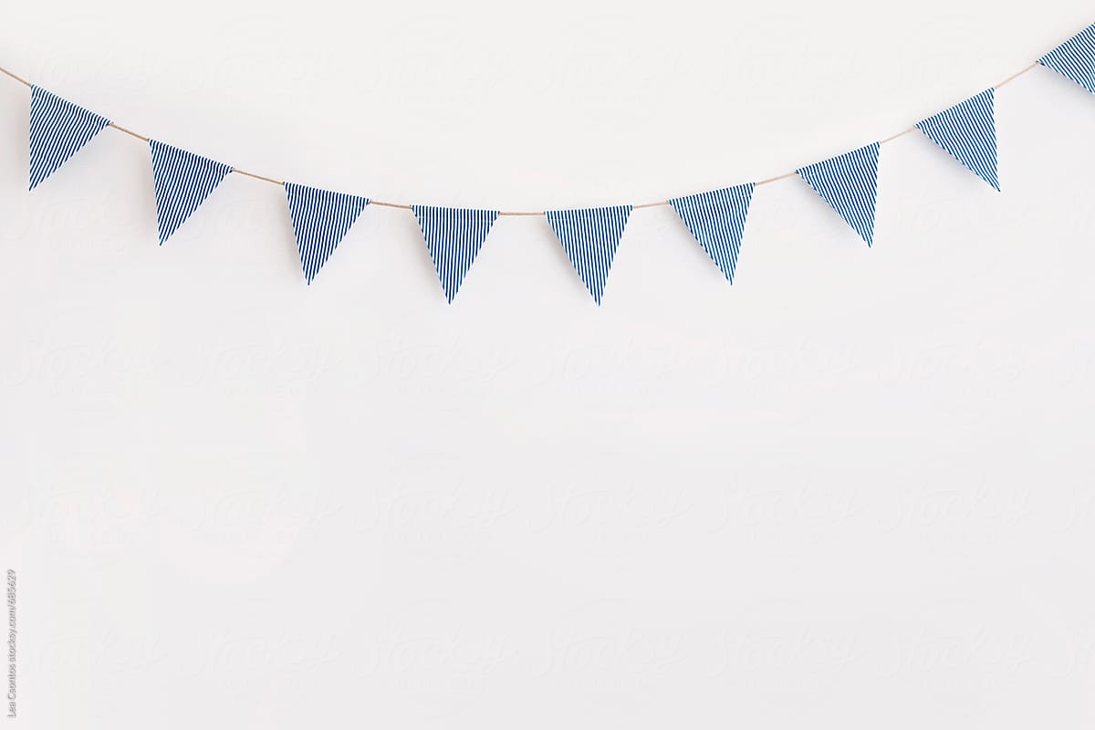 Blue and white striped bunting hanging against a white wall