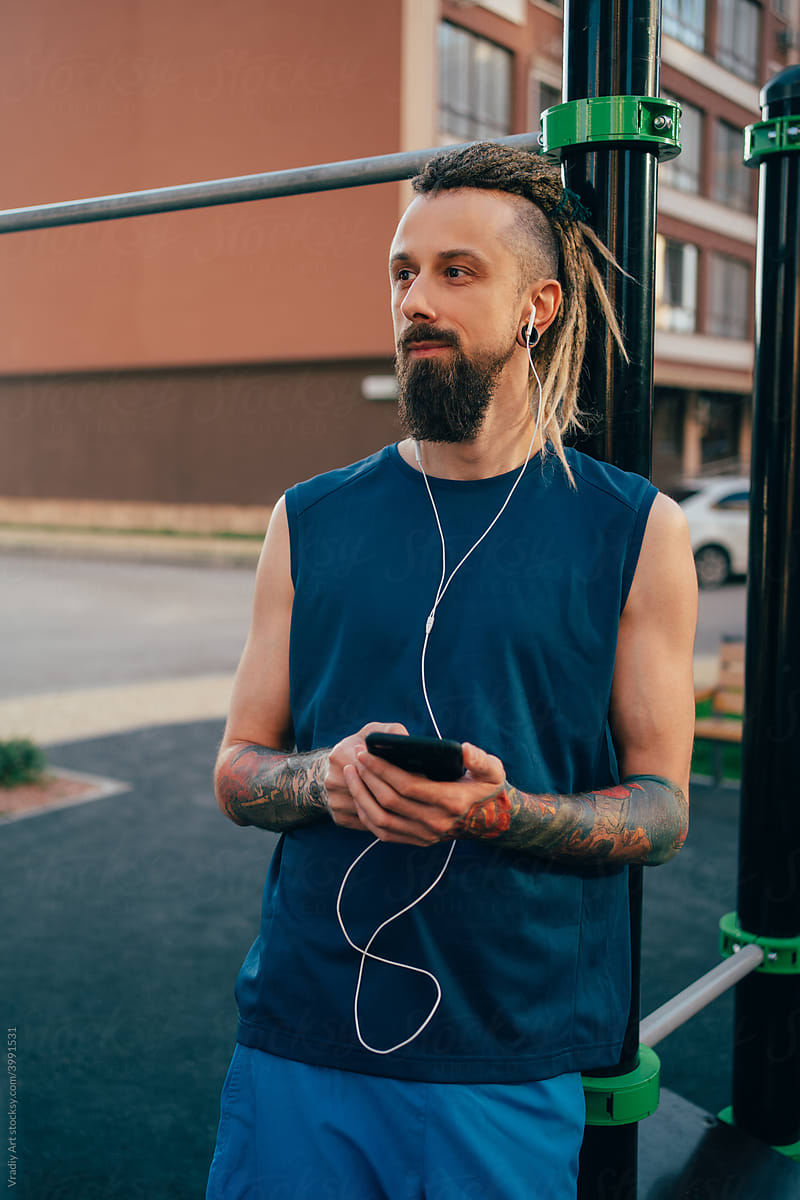 Informal young man listening to music on workout
