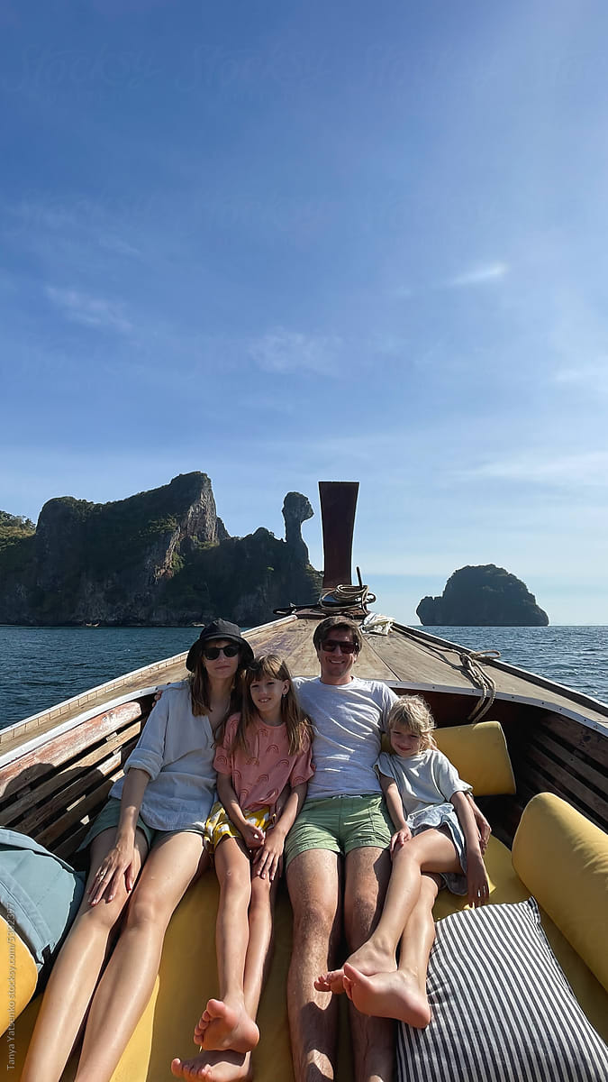 A vertical selfie of a family in the boat in Thailand