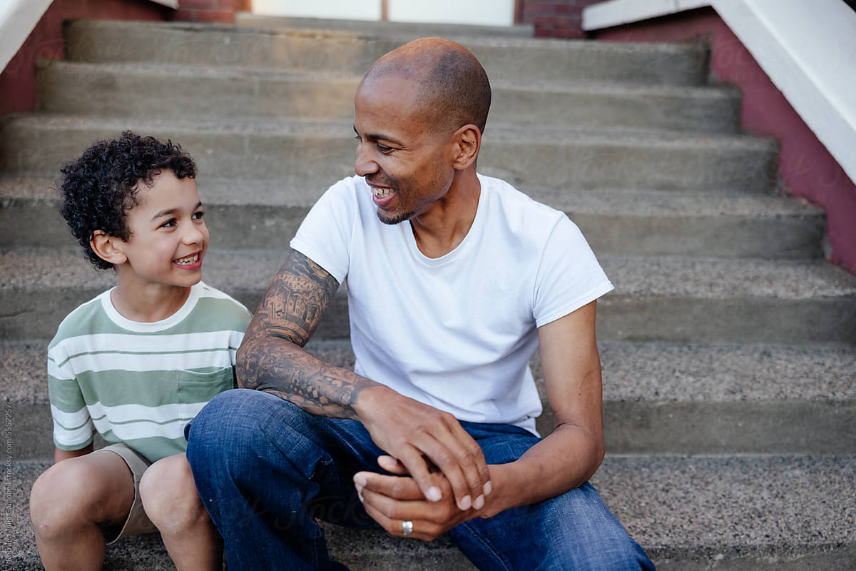 Man and child enjoying talking outside on steps.