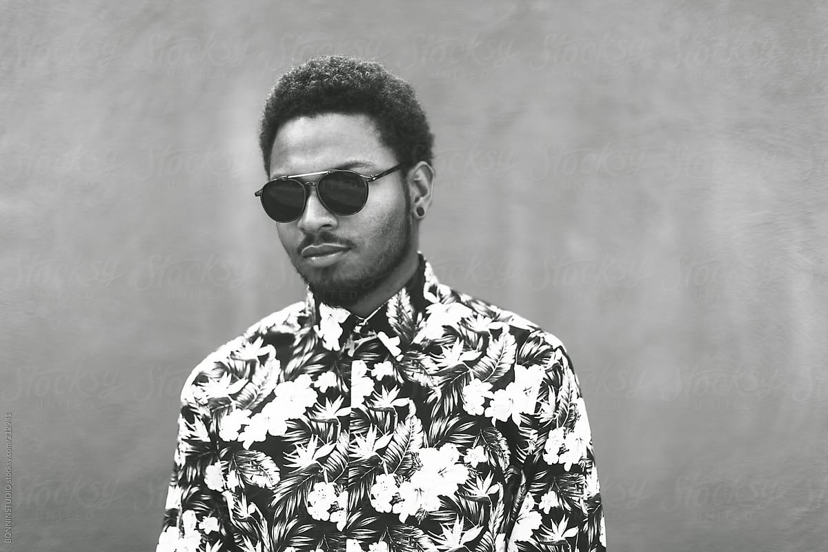 Portrait of modern young black man with sunglasses on black and white.