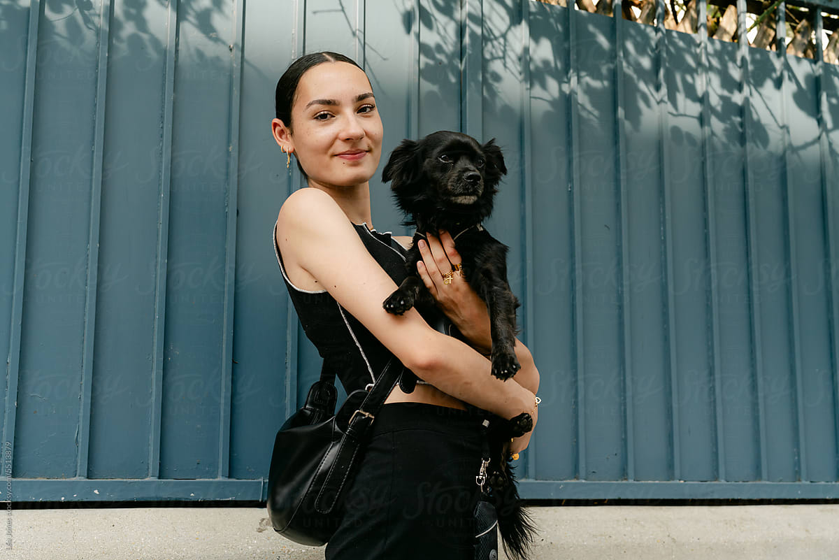 portrait of happy stylish woman in the street with her dog