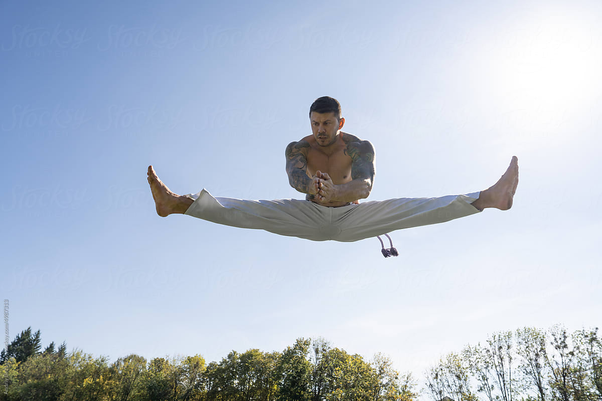 Attractive man performing a capoeira kick. Exercising of fighter