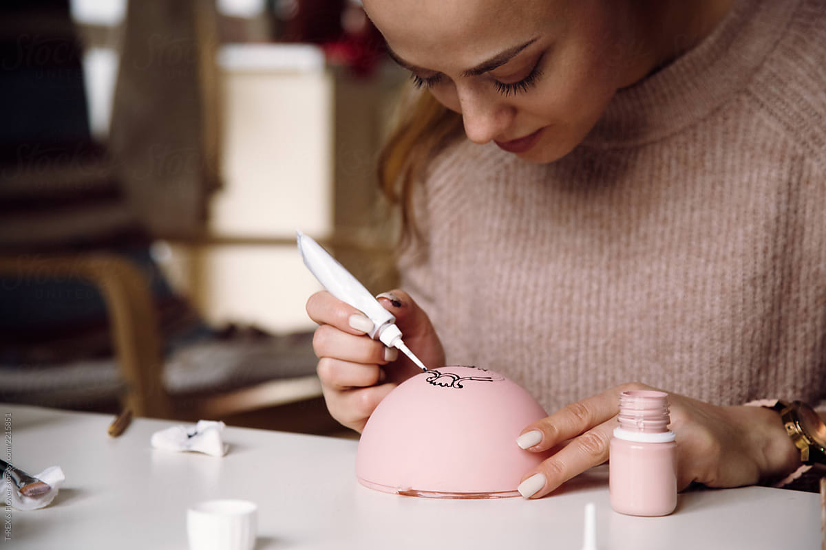 Concentrated woman creating stylish pink bauble