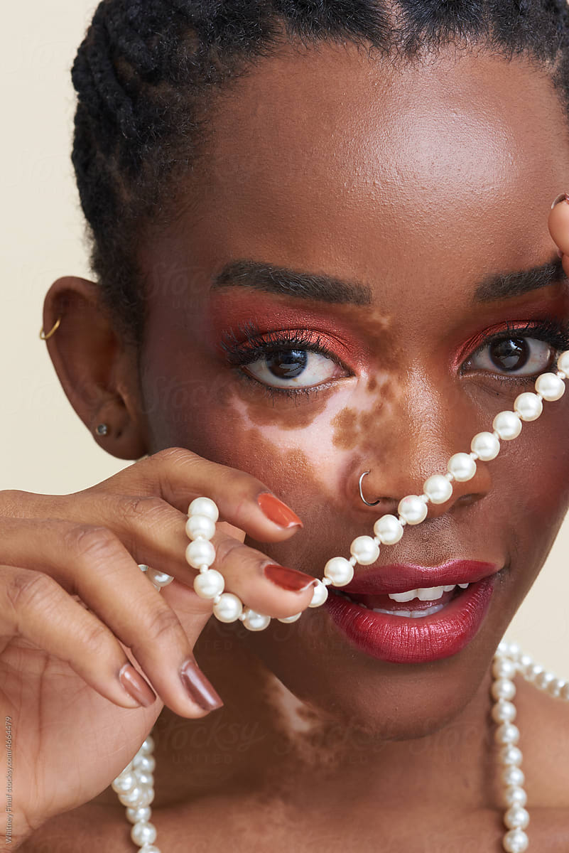 Close Up Image of Young Black Woman Holding Pearls