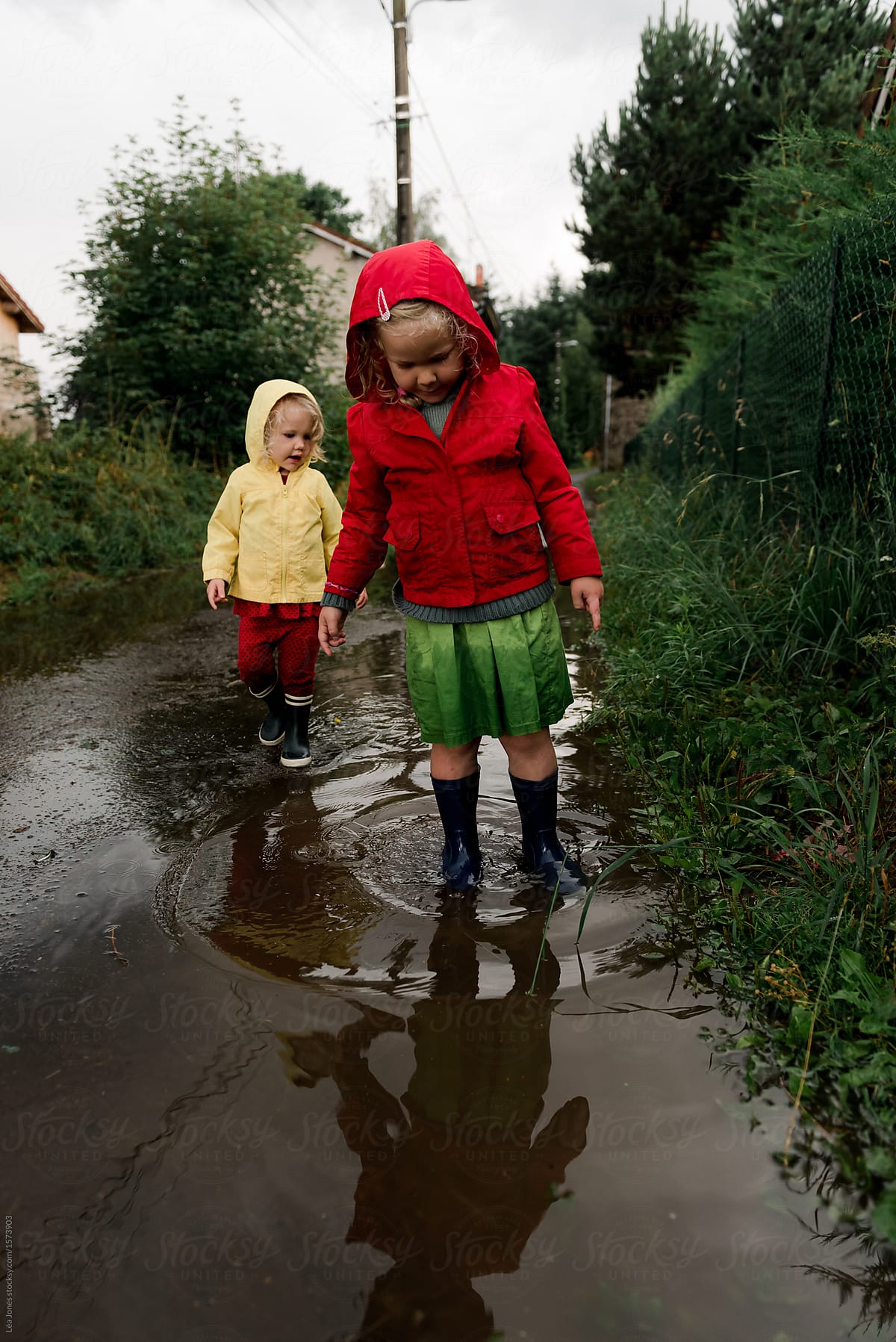 two girls playing in the street after the rain
