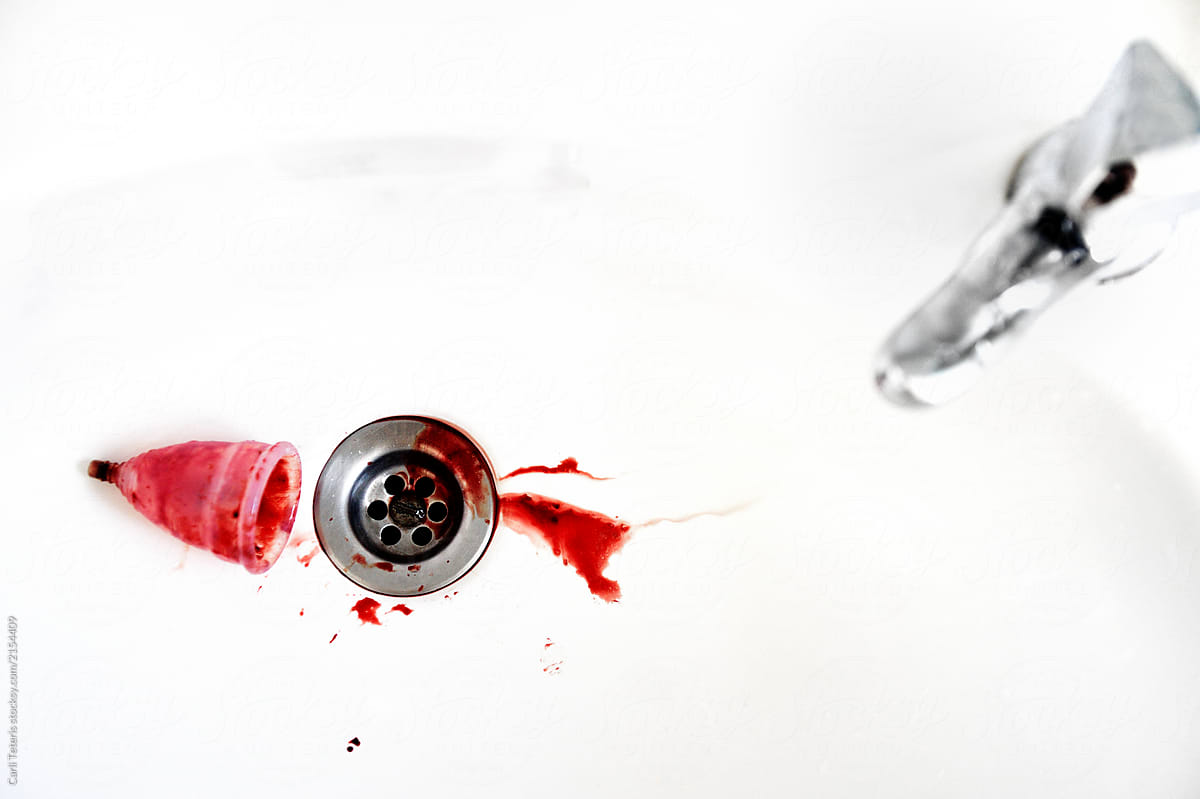 Menstrual cup emptied into a sink drain