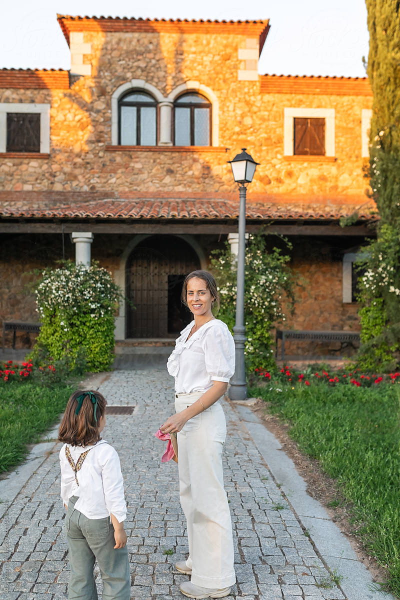 mother with her little daughter in front of her country house