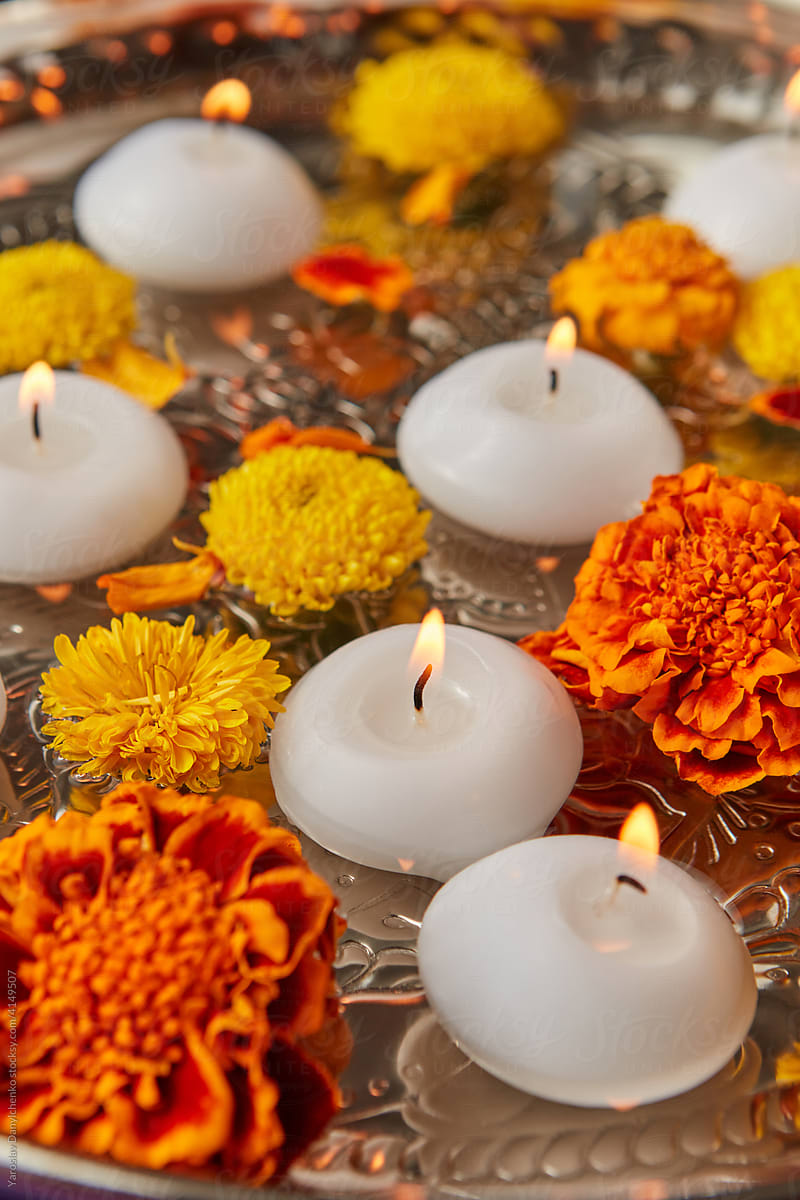 Closeup of orange and yellow flowers and candles