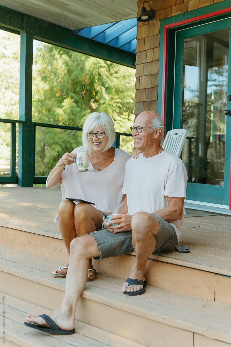 Happy elderly couple drinking coffee on deck